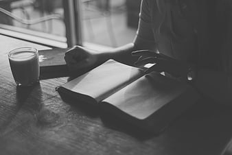 Woman Reading Book with Milk at Wooden Table