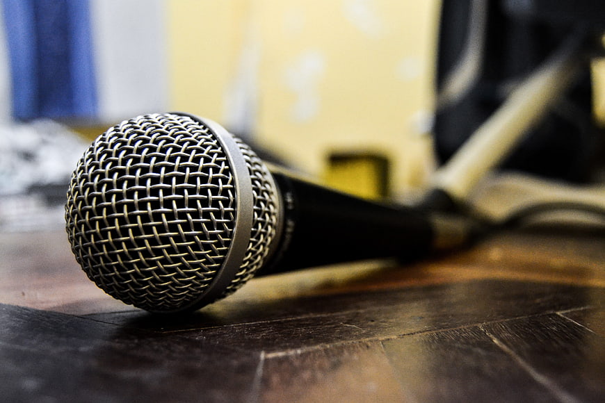 Close-up of silver microphone on wooden table