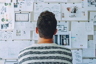 Man Analyzing Project Plans on Wall