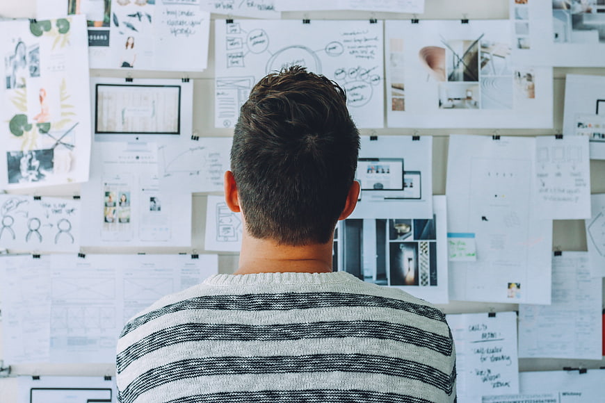 Man Analyzing Project Plans on Wall