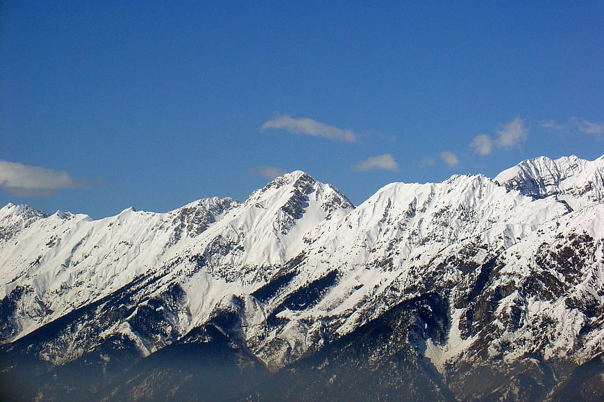 Snow-Covered Mountain Peaks Against Blue Sky