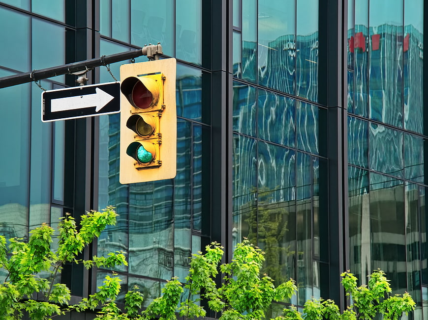 Green Traffic Light Signal Against Modern Glass Building