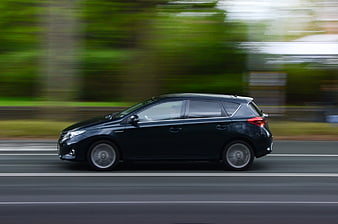 Black Hatchback Car Driving Fast on Road with Motion Blur