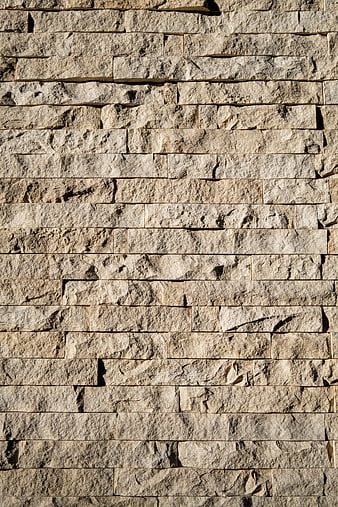 Textured beige stone wall background with horizontal masonry pattern