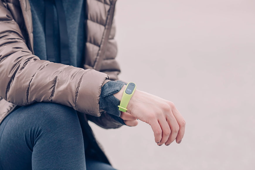 Woman Checking Green Fitness Tracker on Wrist