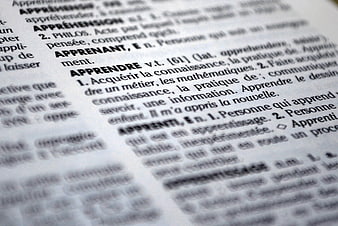 Close-up of French dictionary page defining the word apprendre