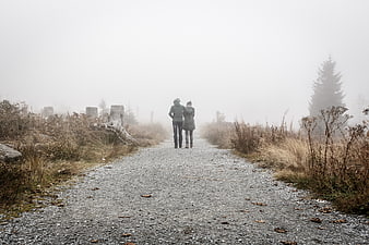 Couple Walking Away on Foggy Gravel Path in Nature