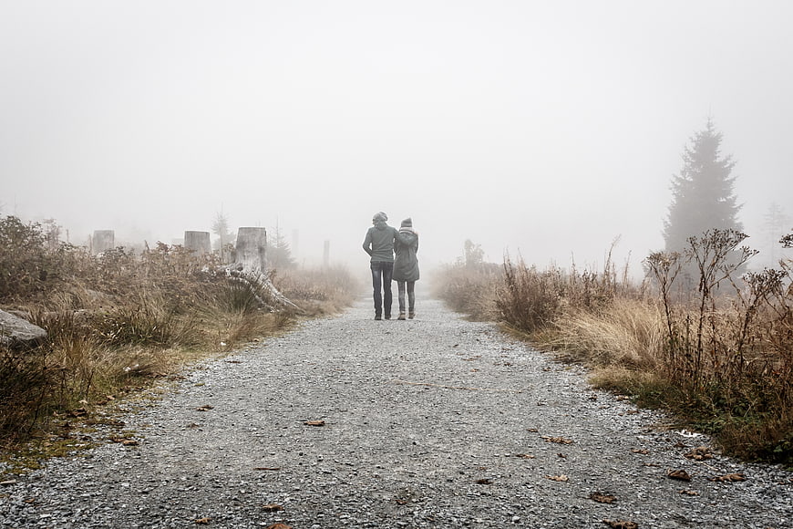 Couple Walking Away on Foggy Gravel Path in Nature