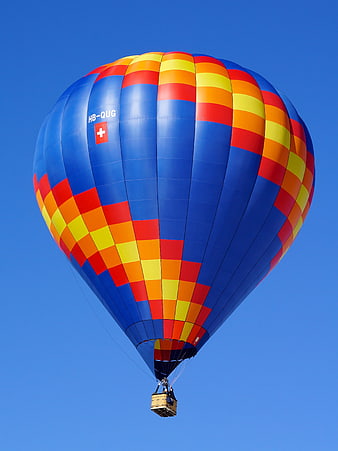 Colorful Swiss Hot Air Balloon Flying in Blue Sky