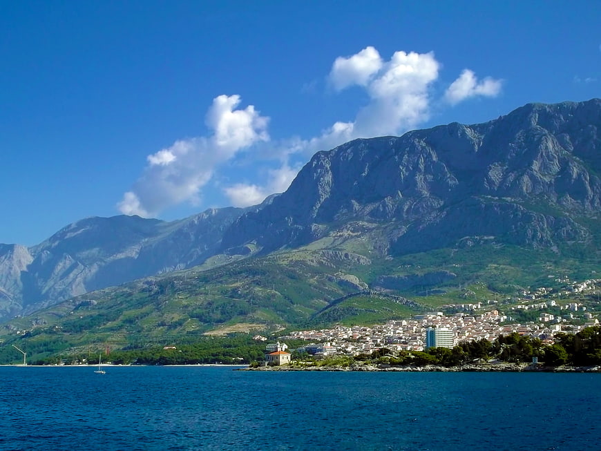 Scenic coastal town nestled at the foot of dramatic mountains