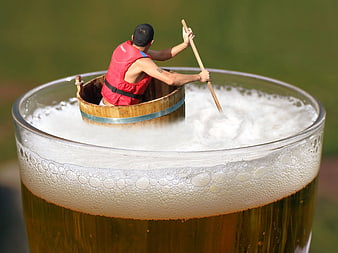 Man rowing barrel boat in giant beer glass