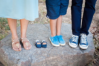 Family Feet and Baby Booties on Rock Maternity Concept