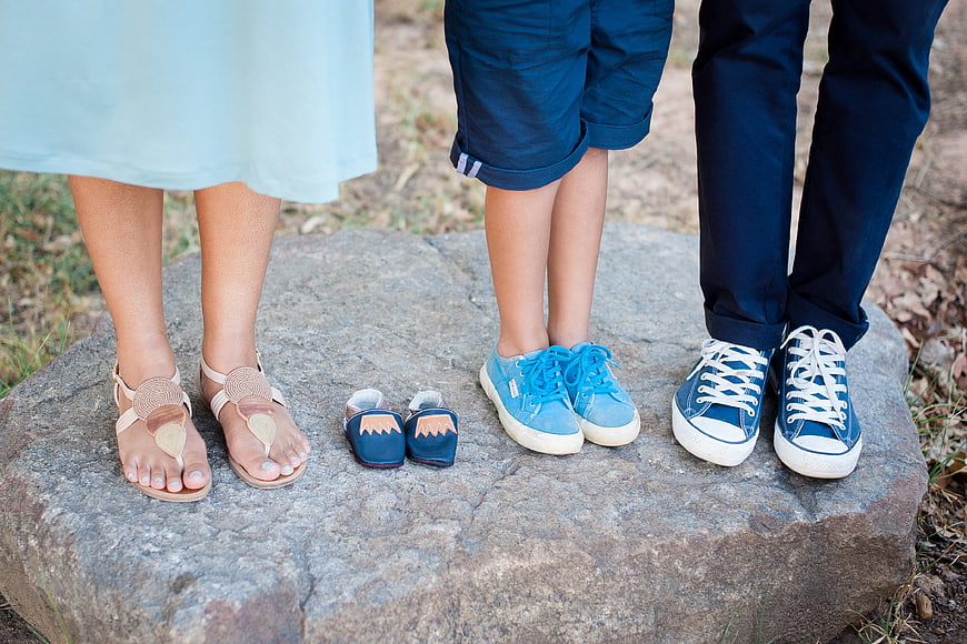 Family Feet and Baby Booties on Rock Maternity Concept