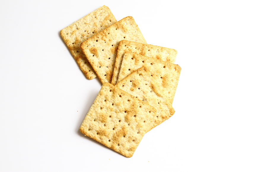 Stack of square wheat crackers on white background