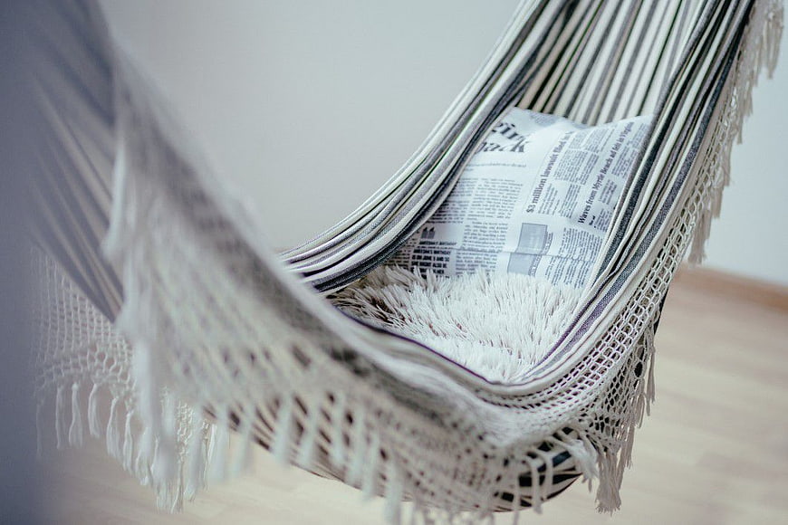 Close-up of white woven hammock with newspaper inside
