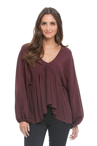 Woman in Burgundy Ruffle Blouse and Black Jeans