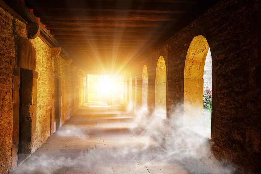 Sunlit Stone Corridor with Mist and Arched Openings