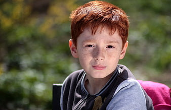 Portrait of a young boy with red hair and freckles