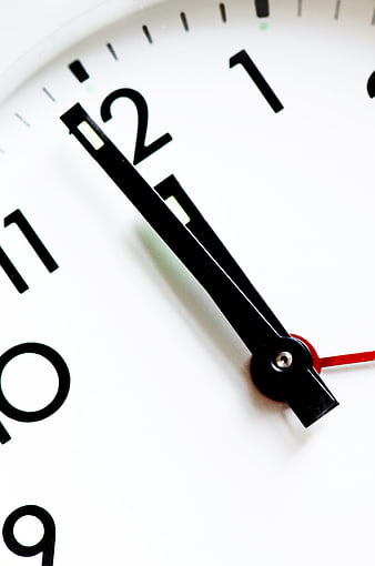 Close-up of analog clock face showing time near twelve