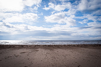 Serene Beach Landscape With Cloudy Sky And Calm Ocean Horizon