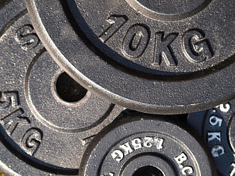 Close-up of stacked black iron weight plates in gym