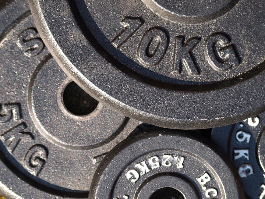 Close-up of stacked black iron weight plates in gym