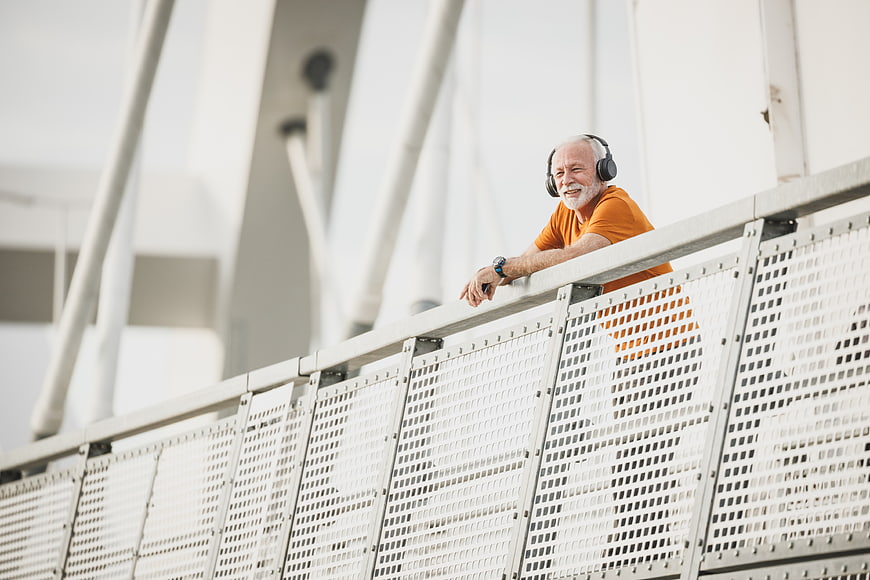 Senior man with headphones on modern bridge
