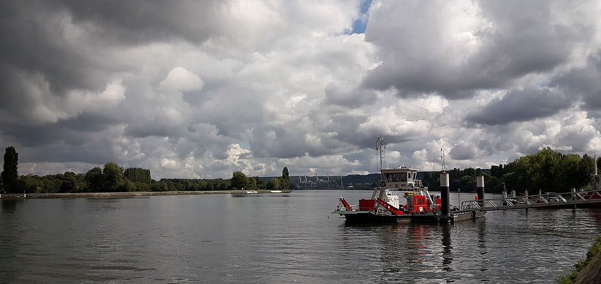 Wide river landscape with dramatic clouds and docked boat