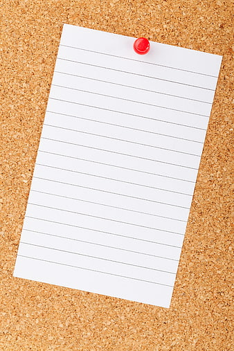 Blank lined paper pinned to cork board with red thumbtack
