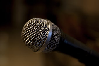 Close-up of a silver microphone head with a dark blurred background