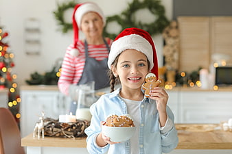 Happy Girl Holding Gingerbread Cookies with Grandmother in Kitchen