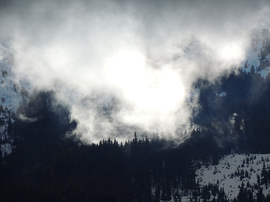 Misty Mountain Forest Landscape with Sunlight Breaking Through Clouds