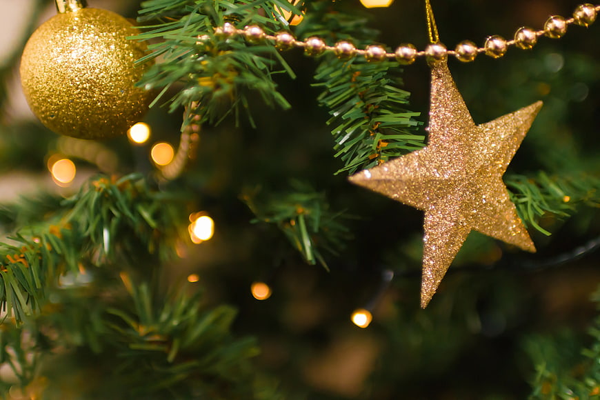 Close-up of Glittering Gold Star Ornament on Christmas Tree