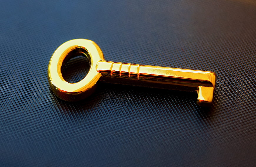 Golden Key On Dark Textured Surface