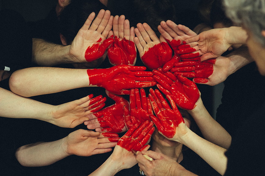 Group of Hands with Red Paint in Circle