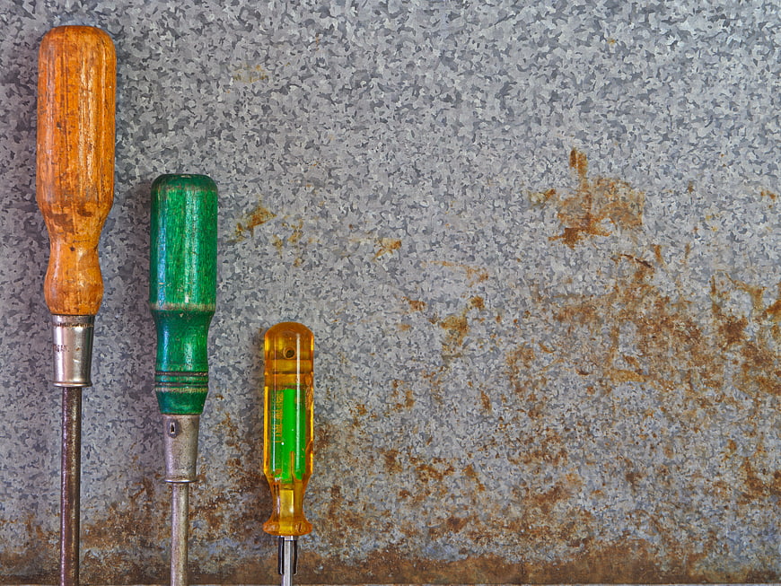 Vintage Screwdrivers on Rusty Metal Background
