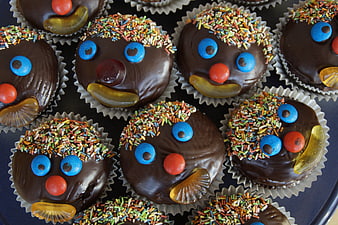 Chocolate Muffins Decorated As Cute Clown Faces With Sprinkles