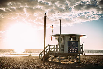Lifeguard Tower on Sandy Beach at Golden Hour Sunset