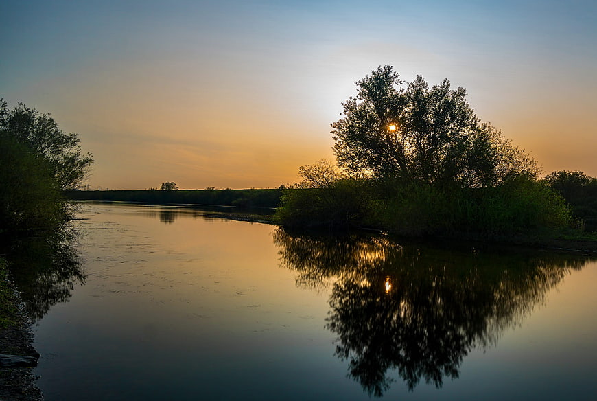 Serene River Sunset with Tree Reflections