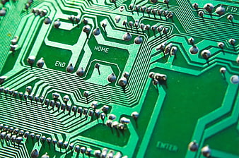 Close-up of green circuit board with solder points and text