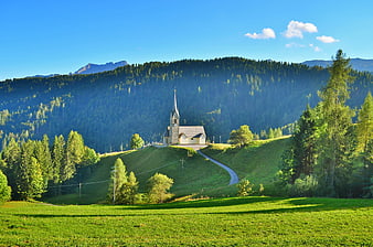 Scenic Church on Green Hilltop with Forest and Mountains
