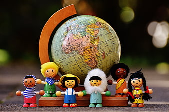 Wooden toy figures representing world cultures holding hands around a globe