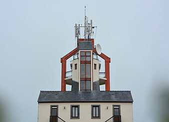 Historic Semaphore Tower With Modern Antennas Against Overcast Sky