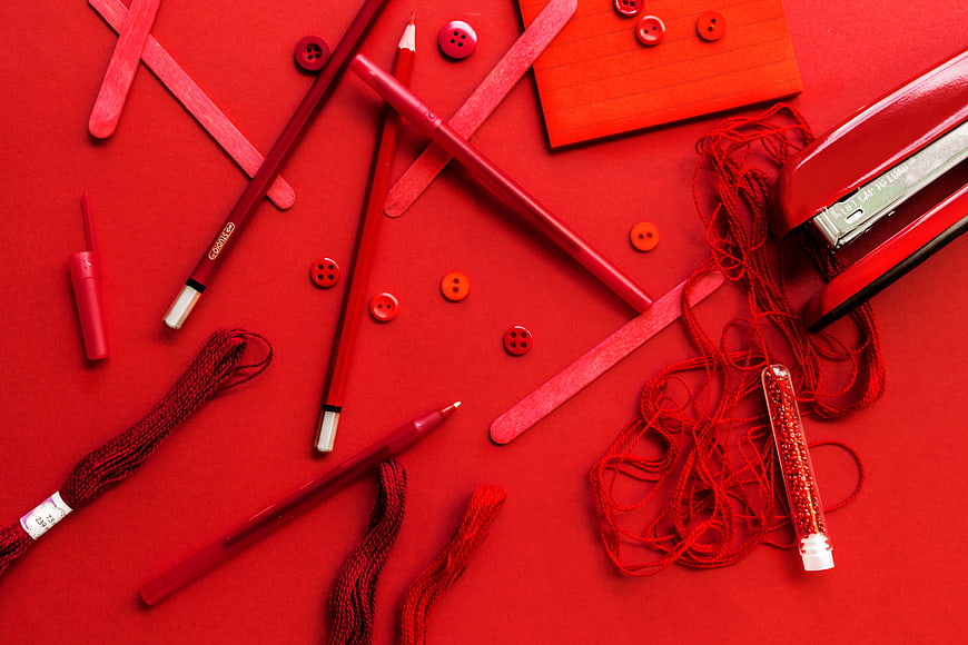 Red monochrome flat lay of craft supplies and stationery