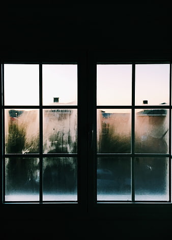 Moody view through dirty window panes at dusk