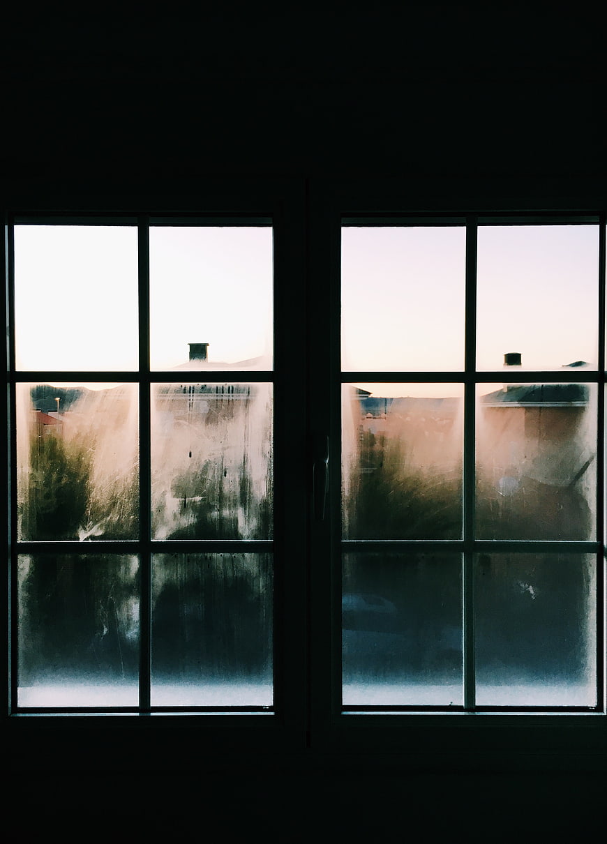 Moody view through dirty window panes at dusk