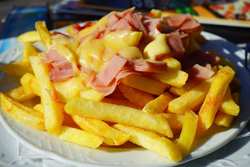 Golden French Fries Topped With Melted Cheese And Ham
