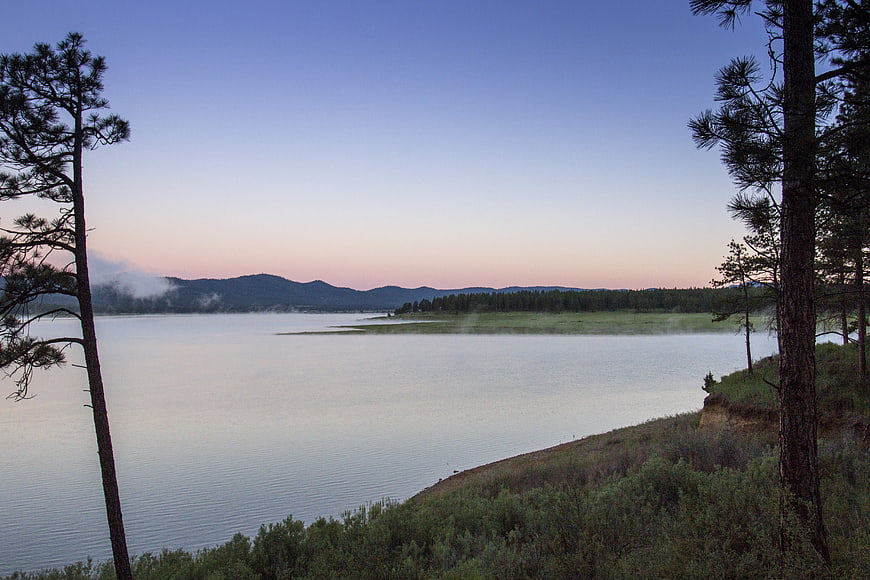 Serene Lake at Dusk with Mist and Pine Trees