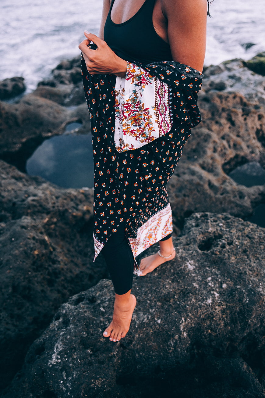 Woman in Boho Coverup Standing on Coastal Rocks