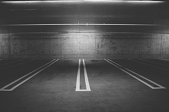 Empty underground parking garage with concrete walls and white lines